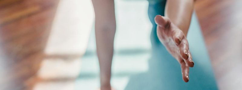 Detail of a person's hands during a yoga pose.